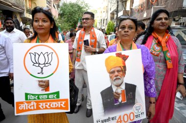 NOIDA, INDIA - 8 Nisan - Gautam Buddh Nagar milletvekili adayı BJP adayı Dr. Mahesh Sharma 'nın eşi Uma Sharma döneminde Modi posterleri taşıyan BJP çalışanları, 8 Nisan 2024' te Lok Sabha seçimleri için seçim kampanyası için kapı kapı dolaşacak.