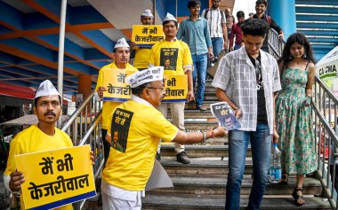 NEW DELHI, INDIA - 15 Nisan 2024: Aam Aadmi Partisi Gönüllüleri pankartları elinde tutuyor ve 15 Nisan 2024 'te Laxmi Nagar Metro' nun dışında Ka Jawab Oy Se Broşürleri dağıtıyor..