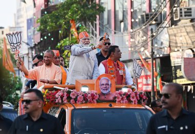GHAZIABAD, INDIA - 6 Nisan 2024 tarihinde Hindistan 'ın Gaziabad kentinde düzenlenen Lok Sabha seçimleri öncesinde Başbakan Narendra Modi ve Uttar Pradesh CM Yogi Adityanath bir yol gösterisi düzenlediler. Parti sembolü 'lotus' u tutan Başbakan Modi tezahürat yapan kalabalığa el salladı 