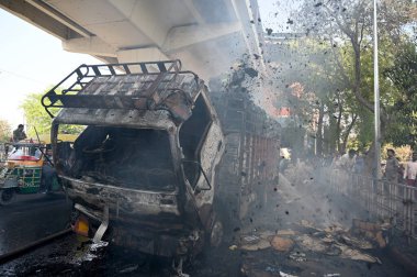 NOIDA, INDIA - 7 Nisan 2024 Noida, Hindistan 'da, Noida City Center metro istasyonu yakınlarındaki bir karton kutuyla dolu bir kamyonda yangını söndüren itfaiye personeli. 
