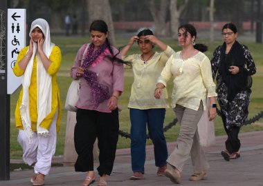 NEW DELHI, INDIA - 13 Nisan 2024: İnsanlar 13 Nisan 2024 tarihinde Yeni Delhi, Hindistan 'da Kartavya Yolu' nda bir toz fırtınasına yakalandı. IMD 'nin dediğine göre, Batı' da yaşanan yoğun bir karışıklık da dahil olmak üzere birkaç hava sisteminin etkisi nedeniyle....