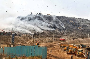 NEW DELHI, INDIA - 22 Nisan 2024: İtfaiyeciler 22 Nisan 2024 'te Yeni Delhi, Hindistan' da Gazipur Çöplük Bölgesi 'ndeki yangını söndürmek için gece gündüz çalışıyorlar.  