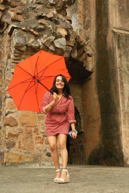 NEW DELHI, INDIA - 13 Nisan 2024: Bollywood oyuncusu Apoorva Arora, 13 Nisan 2024 tarihinde Hindistan 'ın Yeni Delhi kentinde, HT City ile özel bir röportaj ve çekim sırasında kırmızı şemsiyeyle poz verdi.