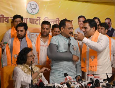 NEW Delhi, INDIA - APRIL 16, 2024: Praveen Kumar son of Congress Leader Jai Kishan from West Delhi and Congress Leader Prateek Anand and other Congress Leaders joining BJP.  clipart