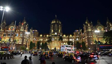 MUMBAI, INDIA - APRIL 16, 2024: Chhatrapati Shivaji Maharaj Terminus illumiated in Golden colour as Indian railway complete its 171 years on April 16, 2024 in Mumbai, India. India first train ride Bori Bunder to Thane completes 171 years. clipart