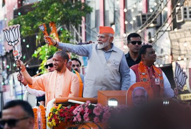 GHAZIABAD, INDIA - 6 Nisan 2024 tarihinde Hindistan 'ın Gaziabad kentinde düzenlenen Lok Sabha seçimleri öncesinde Başbakan Narendra Modi ve Uttar Pradesh CM Yogi Adityanath bir yol gösterisi düzenlediler. Parti sembolü 'lotus' u tutan Başbakan Modi tezahürat yapan kalabalığa el salladı 