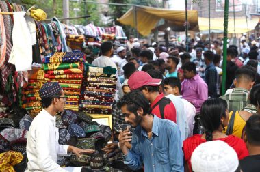 GURUGRAM, INDIA - 10 Nisan 2024 'te Hindistan' ın Gurugram kentinde, Sohna Chowk yakınlarındaki Sadar Bazar 'da Kurban Bayramı arifesinde Jama Mescid' in dışında alışveriş yapan insanlar. 