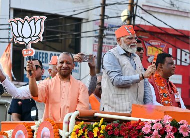 GHAZIABAD, INDIA - 6 Nisan 2024 tarihinde Hindistan 'ın Gaziabad kentinde düzenlenen Lok Sabha seçimleri öncesinde Başbakan Narendra Modi ve Uttar Pradesh CM Yogi Adityanath bir yol gösterisi düzenlediler. Parti sembolü 'lotus' u tutan Başbakan Modi tezahürat yapan kalabalığa el salladı 