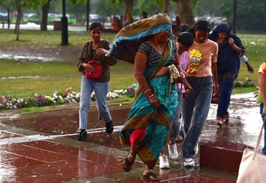 NEW DELHI, INDIA - 13 Nisan 2024 'te Yeni Delhi, Hindistan' da Kartavaya Yolu 'nda bulutlar ve güçlü rüzgar esintisi eserken ziyaretçiler görülüyor. IMD, çeşitli hava sistemlerinin etkisinden dolayı