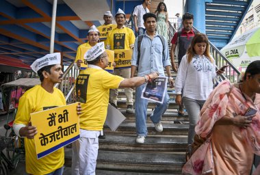 NEW DELHI, INDIA - 15 Nisan 2024: Aam Aadmi Partisi Gönüllüleri pankartları elinde tutuyor ve 15 Nisan 2024 'te Laxmi Nagar Metro' nun dışında Ka Jawab Oy Se Broşürleri dağıtıyor..