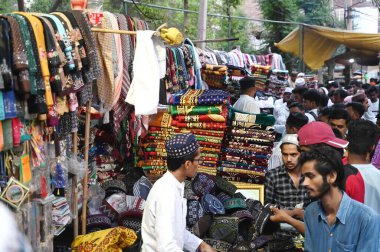 GURUGRAM, INDIA - 10 Nisan 2024 'te Hindistan' ın Gurugram kentinde, Sohna Chowk yakınlarındaki Sadar Bazar 'da Kurban Bayramı arifesinde Jama Mescid' in dışında alışveriş yapan insanlar. 