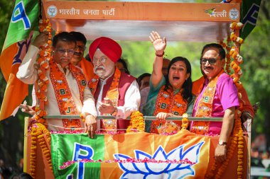 NEW DELHI, INDIA - APRIL 30, 2024: Basuri Swaraj, BJP's Candidate from New Delhi Constituency for upcoming Loksabha Elections seen along Delhi BJP President Virendra Sachdeva and BJP Leader Hardeep Puri during a Roadshow before filing her nomination. clipart