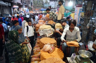 GURUGRAM, INDIA - 10 Nisan 2024 'te Hindistan' ın Gurugram kentinde, Sohna Chowk yakınlarındaki Sadar Bazar 'da Kurban Bayramı arifesinde Jama Mescid' in dışında alışveriş yapan insanlar. 