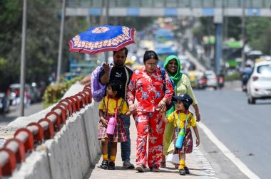 İnsanlar sıcak bir öğleden sonra Shakarpur üstgeçidinde 20 Nisan 2024 'te Yeni Delhi, Hindistan' da serap içinde yürür.