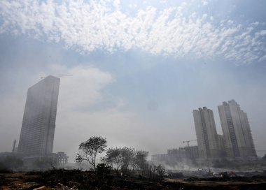 NOIDA, INDIA - 27 Mart 2024: İtfaiyeciler Sektör 32 'deki çöplük bahçesinde yangın söndürmeye çalışıyorlar. Pazartesi günü saat 18.00 sularında başlayan yangın, 32. Sektör 'de yaklaşık 1,5 km genişliğinde ve 2 km uzunluğunda bir alanı sardı.