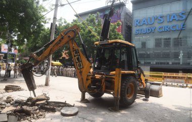 NEW DELHI, INDIA - 29 Temmuz 2024: Bir buldozer olarak polis personeli, Eski Rajinder Nagardaki IAS koçluk enstitüsünün parçalarını yok etti.