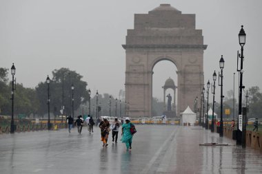 NEW DELHI, INDIA - 2 Mart 2024 'te Hindistan' ın Yeni Delhi şehrinde insanlar hafta sonu Kartavya Yolu 'nda yağmurlu havanın keyfini çıkarırken görüldü. Cumartesi günü yağan yağmur, başkentin bazı bölgelerini kirleterek kentteki kirlilik seviyelerini düşürdü. 