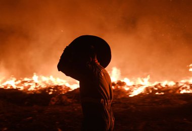 NOIDA, INDIA - 25 Mart 2024: Pazartesi akşamı Sektör 32 'deki boş bir arsada meydana gelen yangın, yakınlardaki bölge sakinlerini boğulma, gözlerinde yanma hissi bıraktı. 20 yangın ihalesi olayı kontrol altına almak için yerinde.