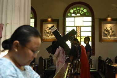 KOLKATA, INDIA - 29 Mart 2024 tarihinde Hindistan 'ın Kolkata kentinde Kutsal Kalp Kilisesi' nde İsa Mesih 'in çarmıha gerilişini yeniden canlandırdılar. Kutsal Cuma, İsa Mesih 'in çarmıha gerilişinin anısıdır. 