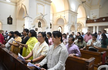 NEW DELHI, INDIA - 31 Mart 2024: İnsanlar Paskalya Pazar günü Yeni Delhi, Hindistan 'da 31 Mart 2024 tarihinde Sacred Heart Katedrali Kilisesi' nde yapılan ayine katıldılar. Pascha ya da Diriliş Pazarı da denir.. 