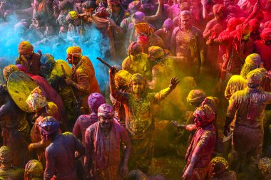 MATHURA, INDIA - 19 Mart 2024: İnsanlar 19 Mart 2024 tarihinde Hindistan 'ın Mathura kentinde Nandji Tapınağı' nda Lathmar Holi festivali sırasında birbirlerine renkli toz sürerler. 