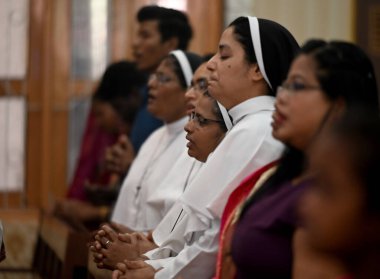 NOIDA, Hindistan - 31 Mart 2024: Paskalya gününde Sektör-34 'teki bir kilisede rahip namaz kılıyor. Paskalya, İsa 'nın çarmıha gerilmesinin ardından yeniden dirilişini kutlamak için kutlanır..