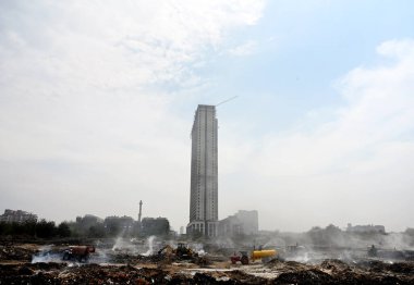 NOIDA, INDIA - 27 Mart 2024: İtfaiyeciler Sektör 32 'deki çöplük bahçesinde yangın söndürmeye çalışıyorlar. Pazartesi günü saat 18.00 sularında başlayan yangın, 32. Sektör 'de yaklaşık 1,5 km genişliğinde ve 2 km uzunluğunda bir alanı sardı.