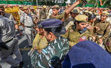 NEW DELHI, INDIA - MARCH 15, 2024: Delhi Police try to stop Hindu Refugees from Pakistan and Afghanistan during a staged protest against Congress over alleged Anti-CAA remarks, near AICC headquarters on March 15, 2024 in New Delhi, India.  clipart