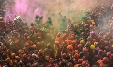 MATHURA, INDIA - 19 Mart 2024: İnsanlar 19 Mart 2024 tarihinde Hindistan 'ın Mathura kentinde Nandji Tapınağı' nda Lathmar Holi festivali sırasında birbirlerine renkli toz sürerler. 