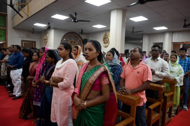 NOIDA, Hindistan - 31 Mart 2024: Paskalya gününde Sektör-34 'teki bir kilisede rahip namaz kılıyor. Paskalya, İsa 'nın çarmıha gerilmesinin ardından yeniden dirilişini kutlamak için kutlanır..