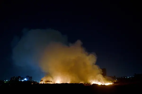 NOIDA, INDIA - 25 Mart 2024: Pazartesi akşamı Sektör 32 'deki boş bir arsada meydana gelen yangın, yakınlardaki bölge sakinlerini boğulma, gözlerinde yanma hissi bıraktı. 20 yangın ihalesi olayı kontrol altına almak için yerinde.