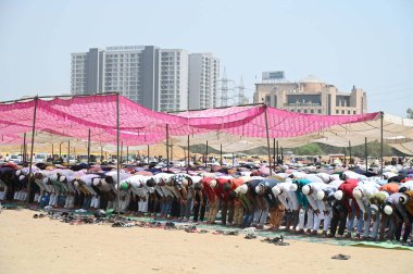 GURUGRAM, INDIA - MARCH 29, 2024: Muslim devotees offer Jummah Namaz on the third Friday of holy month of Ramadan at a ground in sector-29 near Leisure Valley Park on March 29, 2024 in Gurugram, India. clipart