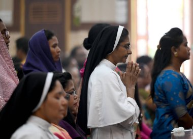 NOIDA, Hindistan - 31 Mart 2024: Paskalya gününde Sektör-34 'teki bir kilisede rahip namaz kılıyor. Paskalya, İsa 'nın çarmıha gerilmesinin ardından yeniden dirilişini kutlamak için kutlanır..