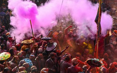 MATHURA, INDIA - 19 Mart 2024: İnsanlar 19 Mart 2024 tarihinde Hindistan 'ın Mathura kentinde Nandji Tapınağı' nda Lathmar Holi festivali sırasında birbirlerine renkli toz sürerler. 
