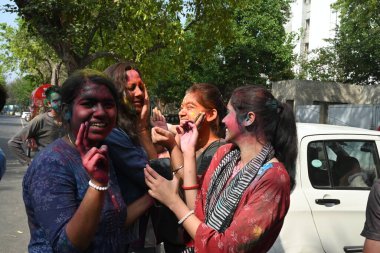 NEW DELHI, INDIA - 21 Mart 2024: Holi Festivali 'nin arifesinde 21 Mart 2024' te Hindistan 'ın Yeni Delhi kentinde üniversiteden ayrıldıktan sonra Holi' yi renkli bir şekilde kutlayan öğrenciler