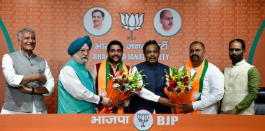 NEW DELHI, INDIA - MARCH 27, 2024: Union Minister Hardeep Singh Puri, BJP National General Secretary Vinod Tawde, president of the Bharatiya Janata Party, Punjab Sunil Kumar Jakhar and others felicitate Aam Aadmi Party''s (AAP) MP Sushil Kumar Rinku. clipart