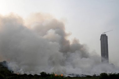 NOIDA, INDIA - 25 Mart 2024: Pazartesi akşamı Sektör 32 'deki boş bir arsada meydana gelen yangın, yakınlardaki bölge sakinlerini boğulma, gözlerinde yanma hissi bıraktı. 20 yangın ihalesi olayı kontrol altına almak için yerinde.