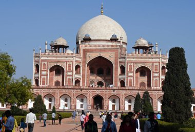 NEW DELHI, INDIA - MARCH 18, 2024: People cover themselves as temperatures are rising in National Capital at Humayuns Tomb on March 18, 2024 in New Delhi, India. After a long winter, Delhi is all set to witness rising temperatures in the coming week. clipart