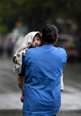 NOIDA, Hindistan - 2 Mart 2024: Noida, Hindistan 'da sabah yağmuru sırasında banliyö sakinleri görüldü. Cumartesi günü yağan yağmur ulusal başkentin bir kısmını kirleterek kentteki kirlilik seviyelerini düşürdü. Delhi 'nin en yüksek sıcaklığı 25.2' de sabitlendi