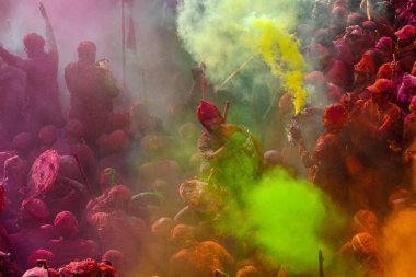 MATHURA, INDIA - 19 Mart 2024: İnsanlar 19 Mart 2024 tarihinde Hindistan 'ın Mathura kentinde Nandji Tapınağı' nda Lathmar Holi festivali sırasında birbirlerine renkli toz sürerler. 