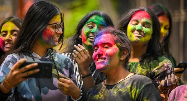 NEW DELHI, INDIA - 21 Mart 2024: Öğrenciler, 21 Mart 2024 'te Hindistan' ın Yeni Delhi kentinde, Matasundari Koleji 'nin önünde Holi festivali öncesinde renklilerle oynuyor
