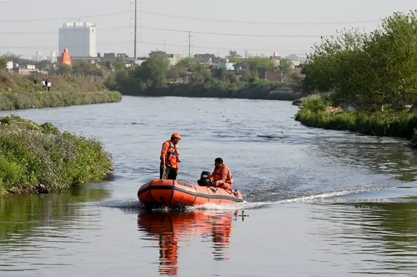 NOIDA, INDIA - 15 Mart 2024: 80. Sektör Kakrala Pusta 'da Hindistan cevizi yakalarken boğulduğu bildirilen çocukları arayan Ulusal Afet Müdahale Gücü (NDRF) personeli