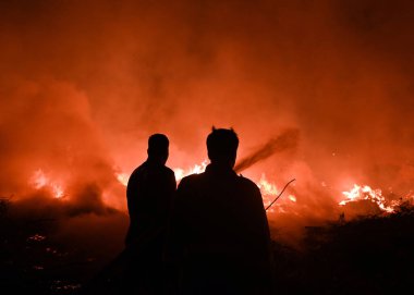NOIDA, INDIA - 25 Mart 2024: Pazartesi akşamı Sektör 32 'deki boş bir arsada meydana gelen yangın, yakınlardaki bölge sakinlerini boğulma, gözlerinde yanma hissi bıraktı. 20 yangın ihalesi olayı kontrol altına almak için yerinde.