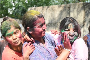 NEW DELHI, INDIA - 21 Mart 2024: Holi Festivali 'nin arifesinde 21 Mart 2024' te Hindistan 'ın Yeni Delhi kentinde üniversiteden ayrıldıktan sonra Holi' yi renkli bir şekilde kutlayan öğrenciler
