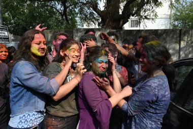 NEW DELHI, INDIA - 21 Mart 2024: Holi Festivali 'nin arifesinde 21 Mart 2024' te Hindistan 'ın Yeni Delhi kentinde üniversiteden ayrıldıktan sonra Holi' yi renkli bir şekilde kutlayan öğrenciler