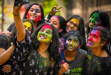 NEW DELHI, INDIA - 21 Mart 2024: Öğrenciler, 21 Mart 2024 'te Hindistan' ın Yeni Delhi kentinde, Matasundari Koleji 'nin önünde Holi festivali öncesinde renklilerle oynuyor