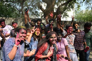 NEW DELHI, INDIA - 21 Mart 2024: Holi Festivali 'nin arifesinde 21 Mart 2024' te Hindistan 'ın Yeni Delhi kentinde üniversiteden ayrıldıktan sonra Holi' yi renkli bir şekilde kutlayan öğrenciler