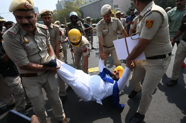 stock image NEW DELHI, INDIA - MARCH 22, 2024: Delhi police personnel detained AAP Leader and Workers during AAP party leaders and worker shouting against Modi government protesting ahead of the appearance of Delhi CM Arvind Kejriwal.