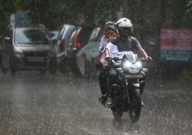 NOIDA, INDIA - 30 Temmuz 2024 'te, nemli bir yazın ardından, akşam yağmuru sırasında Noida, Hindistan' da işe gidip gelenler. (Fotoğraf: Sunil Ghosh / Hindustan Times 