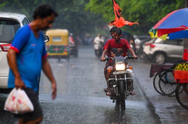 NOIDA, INDIA - 30 Temmuz 2024 'te, nemli bir yazın ardından, akşam yağmuru sırasında Noida, Hindistan' da işe gidip gelenler. (Fotoğraf: Sunil Ghosh / Hindustan Times 
